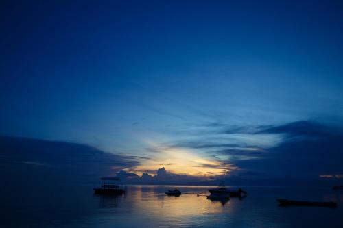 a group of boats in the water at sunset at Tropical Fun Ta Sea Rentals in Siquijor