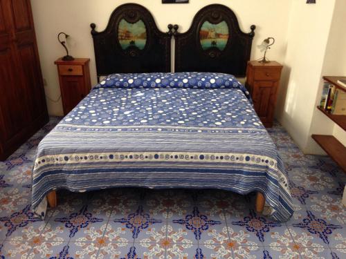 a bed room with a blue and white bedspread at La Lampara in Stromboli