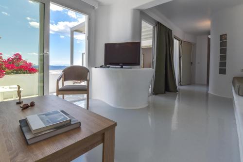 a living room with a tv and a table at Cavos in Agios Sostis