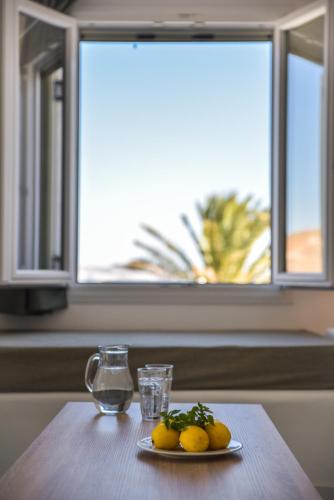 a plate of lemons on a table in front of a window at Cavos in Agios Sostis