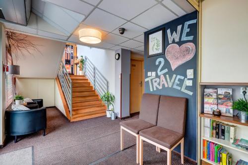 une salle d'attente avec une chaise et un escalier dans l'établissement Smart2Stay Magnolia, à Varsovie
