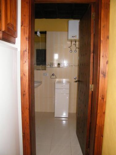 y baño con lavabo, lavadora y secadora. en Casa Rural San José en San Isidro