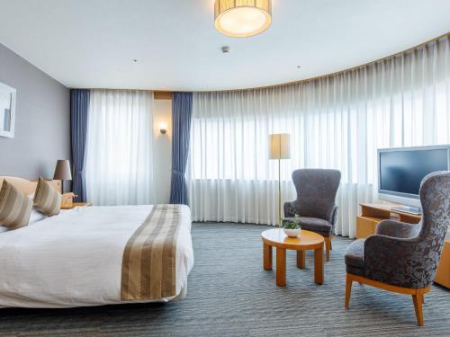 岡山市にある後楽ホテルのベッド1台、薄型テレビが備わるホテルルームです。