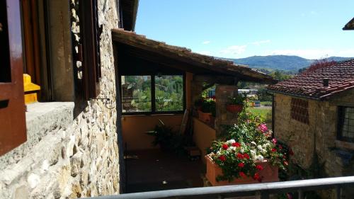 an open door of a building with flowers in a window at Colonica Montebeni in Greve in Chianti