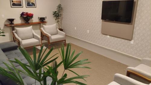 a waiting room with chairs and a flat screen tv at Paracambi Top Hotel in Paracambi