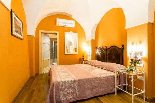 a bedroom with orange walls and a bed at Hotel Villa Gli Asfodeli in Tresnuraghes