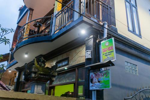 a street sign in front of a building with a balcony at Yoga's House in Ubud