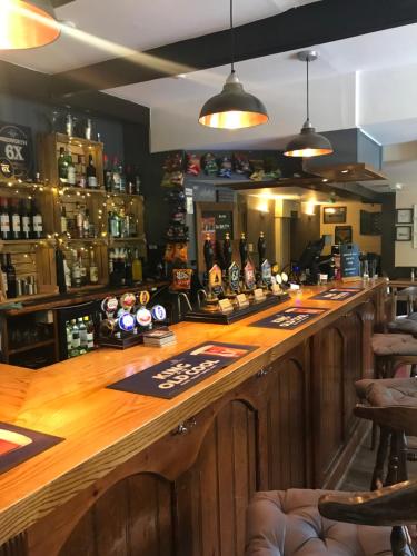 un bar con barra de madera en un restaurante en The Old Ham Tree en Holt