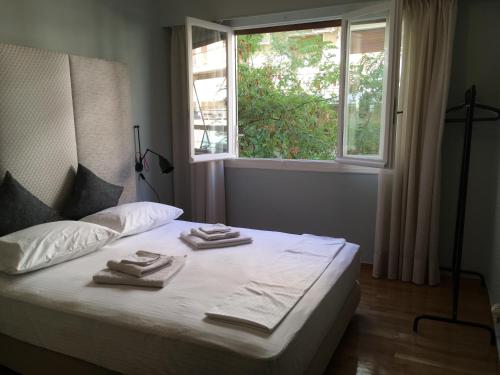 a bed with towels on it with a window at Four Seasons Apartment in Athens