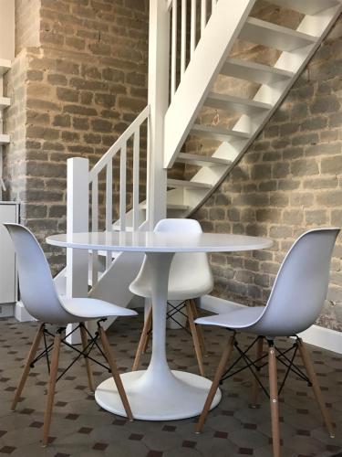 una mesa y sillas en una habitación con escaleras en Guesthouse Bernardin, en Amberes