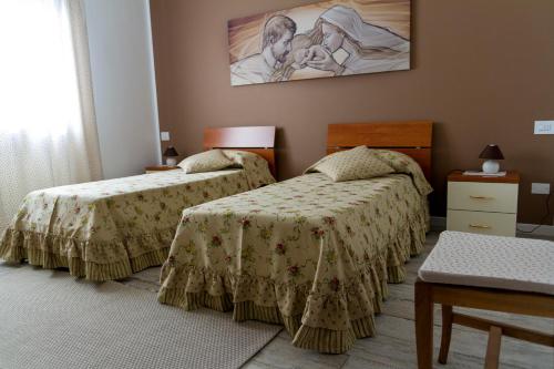 ポンツァーノ・ヴェネトにあるB&B La Rinascitaのベッドルーム1室(ベッド2台付)が備わります。壁には絵画が飾られています。