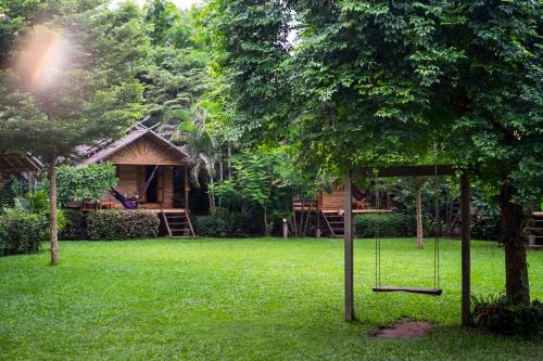 a house with a picnic table and chairs in front of it at Pai Country Hut in Pai