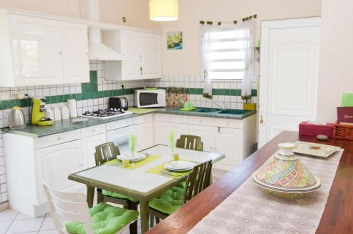 a kitchen with a table and a dining room at A La Maison De Nani in Saint-Paul