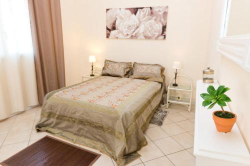 ein Schlafzimmer mit einem Bett und einer Topfpflanze in der Unterkunft A La Maison De Nani in Saint-Paul