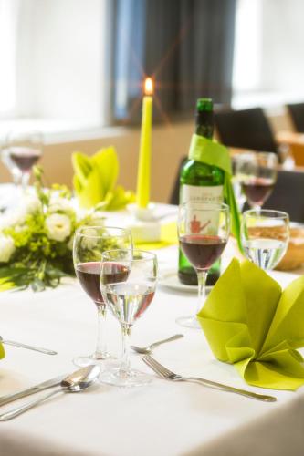 a table with wine glasses and a bottle of wine at Hotel Ostseeländer in Züssow