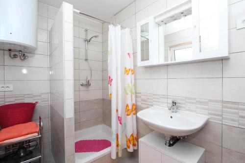 a white bathroom with a sink and a shower at Apartments Monpeloso in Rovinj