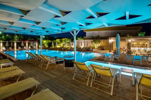 a swimming pool with chairs and a table and a pool at Nissia Kamares in Kardamaina