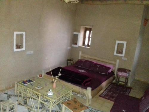 a bedroom with a bed and a table at Kasbah Izoran in Midelt