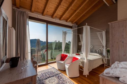 1 dormitorio con cama con dosel y ventana grande en Agriturismo due Carpini, en Valdobbiadene