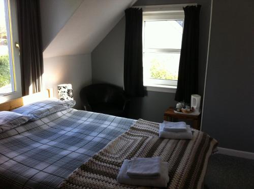 a bedroom with a bed with two towels on it at The Whitehouse in Dingwall