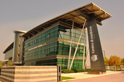 un grand bâtiment en verre avec un vert dans l'établissement Star Hotel Airport Verona, à Dossobuono