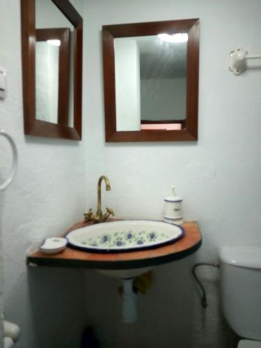 a bathroom with a sink and a toilet and mirrors at Alojamiento rural El Batán in Priego de Córdoba