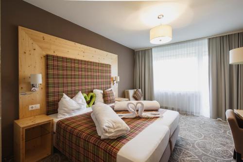 ein Hotelzimmer mit einem Bett und einem großen Fenster in der Unterkunft Boutique Hotel Erla in Stubenberg
