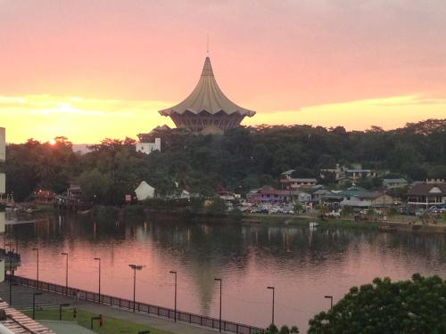 a view of a river with a large building at Woodpecker Lodge, Kuching in Kuching