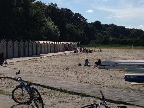 Una bicicleta estacionada en una playa con gente en ella en Regard Sur La Baie, en Saint-Valery-sur-Somme