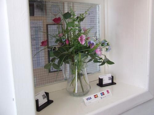a vase of flowers sitting on a window sill at Alexandra Guest House in Hemel Hempstead