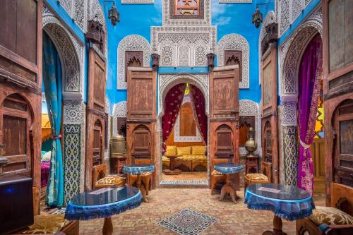a mosque with blue walls and blue tables at Riad Hiba in Meknès