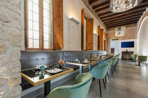 a dining room with long tables and green chairs at Argentina Residenza Style Hotel in Rome