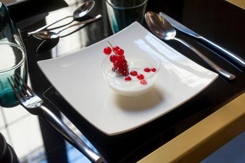 a white plate with a bowl of fruit on a table at Argentina Residenza Style Hotel in Rome
