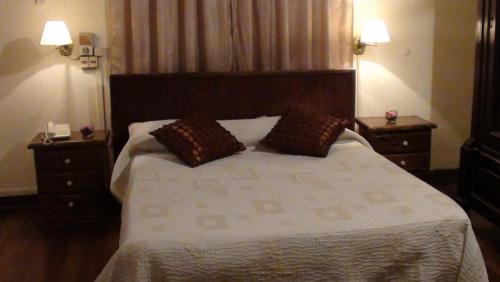 a bedroom with a large bed with two night stands at Hotel Uruguay in Montevideo