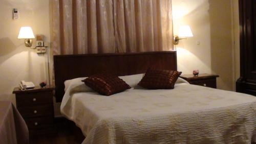 a bedroom with a bed with two pillows on it at Hotel Uruguay in Montevideo