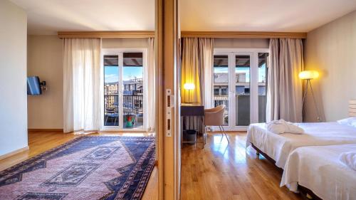 um quarto de hotel com uma cama e uma varanda em Astoria em Tessalónica