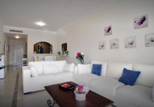 salon z białą kanapą i stołem w obiekcie Apartamento familiar con JARDIN y TERRAZA Privada w mieście La Alcaidesa