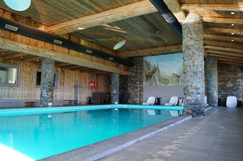 una piscina en un edificio con techo de madera en Myplagne les hauts bois, en Aime La Plagne