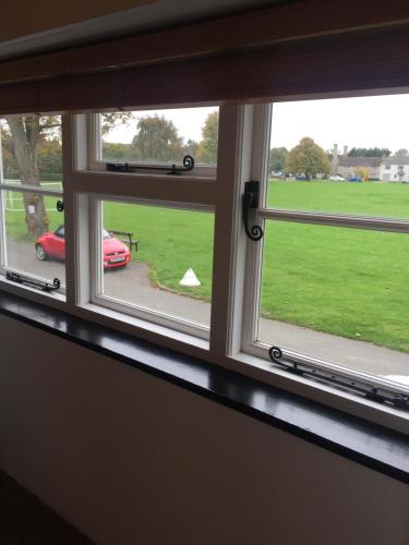 two windows in a room with a view of a field at Cottage on the Green in Brackley