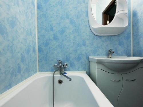 a bathroom with a sink and a tub and a mirror at Apartlux on Novy Arbat Street in Moscow