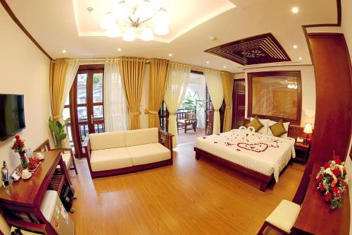 a bedroom with a bed and a living room at Hanoi Nostalgia Hotel & Spa in Hanoi