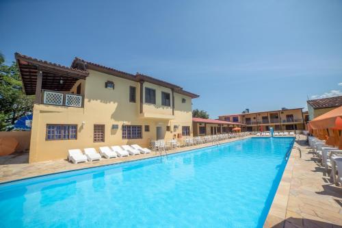 a swimming pool at a hotel with lounge chairs at Hotel Mar in Caraguatatuba