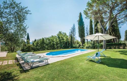 a swimming pool with chairs and an umbrella at Podere Suvignano in Murlo