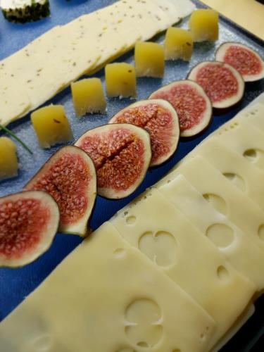 a cutting board with slices of figs and cheese at Kurhotel Anders in Bad Füssing
