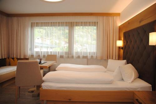 1 dormitorio con 2 camas, escritorio y ventana en Gästehaus Pirker en Finkenberg