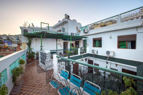 uma varanda de um hotel com cadeiras e mesas em La Colombe Blanche em Moulay Idriss