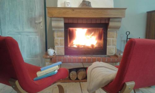 a living room with two chairs and a fireplace at Ranczo w Dolinie Karpia - blisko "Energylandii" Zator in Spytkowice