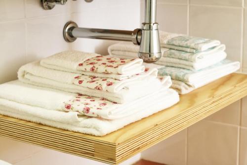 a stack of towels on a shelf in a bathroom at Invictus Place in Porto