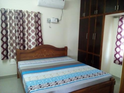 um pequeno quarto com uma cama e uma janela em G k Homestay em Tirupati