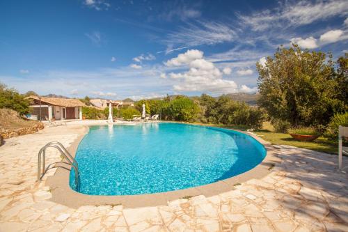 una gran piscina azul en un patio en I Mandorli, en Lotzorai